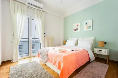 a bedroom with a bed and a large window at Cozy Pangrati Hideaway in Athens