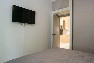 a bedroom with a bed with a flat screen tv on the wall at Modern Flat in Exarchia in Athens