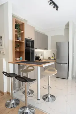 a kitchen with a island with bar stools and a refrigerator at Modern Flat in Exarchia in Athens
