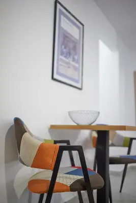 a dining room table with a chair and a wooden table at ARIS Central Kallithea in Athens
