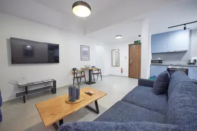 a living room with a blue couch and a table at ARIS Central Kallithea in Athens