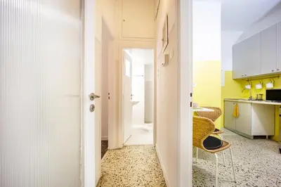 a room with a hallway with a chair and a kitchen at Stylish Modern Athens apt in Athens