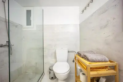 a bathroom with a toilet and a glass shower at Stylish Modern Athens apt in Athens