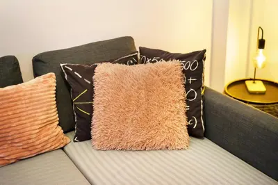 a couch with pillows on it with at Stylish Modern Athens apt in Athens