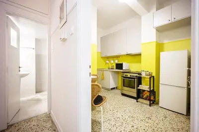 a kitchen with yellow walls and a white refrigerator at Stylish Modern Athens apt in Athens
