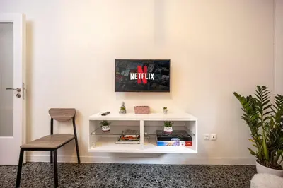 a white book shelf in a room with a chair at Stylish Modern Athens apt in Athens