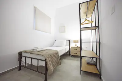 a small bedroom with a bed and a mirror at ARIS Kallithea- Big & Bright 3 Bedroom Apartment in Athens