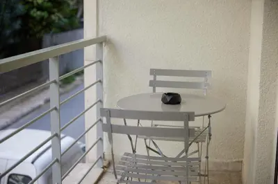 a table on a balcony with a hat on it at ARIS Kallithea- Big & Bright 3 Bedroom Apartment in Athens