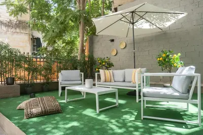 a patio with two chairs and a table and an umbrella at Silk Athens Urban Collection in Athens
