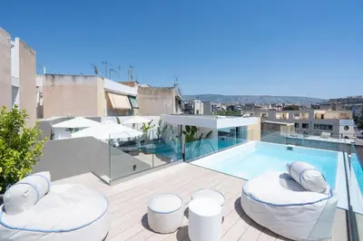 a balcony with a swimming pool and two chairs at Silk Athens Urban Collection in Athens