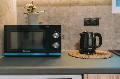 a microwave sitting on a counter next to a coffee pot at Palm & Spa in Barbaliáki