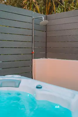 a bath tub in front of a wooden fence at Palm & Spa in Barbaliáki