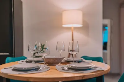a wooden table with wine glasses and plates on it at Palm & Spa in Barbaliáki