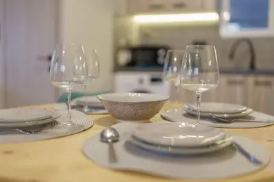 a table with plates and wine glasses on it at Palm & Spa in Barbaliáki