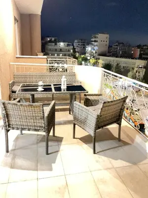 a balcony with a table and chairs on a roof at Bluebay Acropolis view comfort apartment 8 in Athens