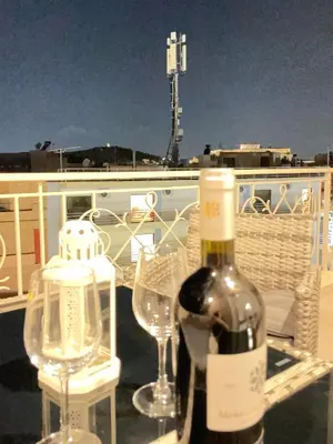 a bottle of wine and two glasses on a boat at Bluebay Acropolis view comfort apartment 8 in Athens