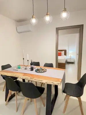 a dining room table with black chairs and a mirror at Bluebay Acropolis view comfort apartment 8 in Athens