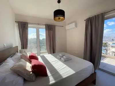 a bedroom with a bed with red pillows and a window at Bluebay Acropolis view comfort apartment 8 in Athens