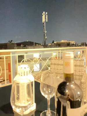 a bottle of wine and two glasses on a balcony at Bluebay Acropolis view comfort apartment 8 in Athens