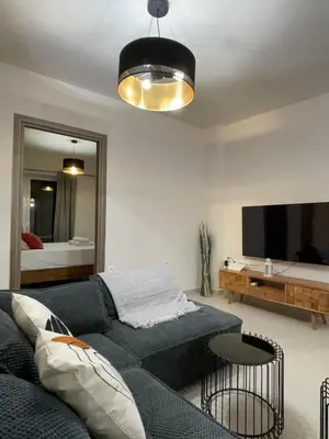 a living room with a blue couch and a mirror at Bluebay Acropolis view comfort apartment 8 in Athens