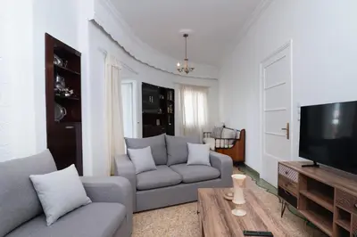 a living room with a couch and a television at Sunrise Apartment By Athens Airport in Spáta