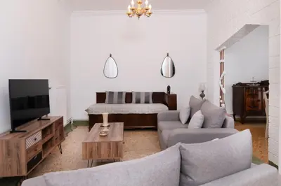 a living room with a couch and a tv at Sunrise Apartment By Athens Airport in Spáta