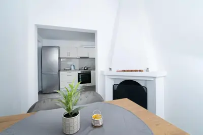 a kitchen and dining room with a table and a fireplace at Sunrise Apartment By Athens Airport in Spáta