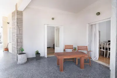a living room with a wooden table and chairs at Sunrise Apartment By Athens Airport in Spáta