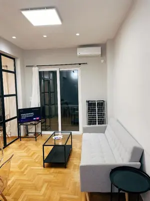 a living room with a couch and a table at Bluebay Cozy apartment 18 in Athens