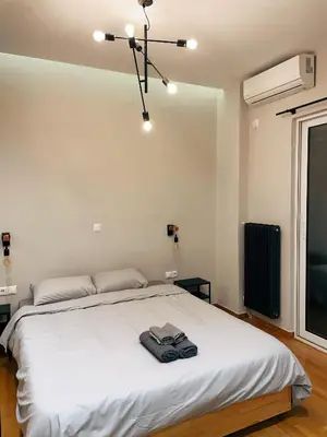 a bedroom with a white bed with a towel on it at Bluebay Cozy apartment 18 in Athens