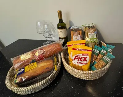 two baskets filled with food and a bottle of wine at Cozy faliro in Piraeus