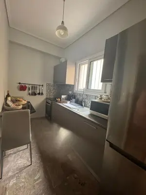 a kitchen with a refrigerator and a table in it at Cozy faliro in Piraeus