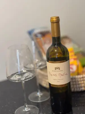 a bottle of wine and two glasses on a table at Cozy faliro in Piraeus