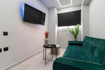 a living room with a green couch and a flat screen tv at Gkr Luxury Apartments Metro Petralona in Athens