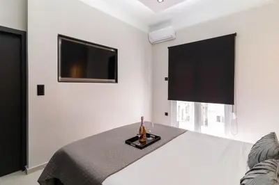 a bedroom with a bed and a flat screen tv at Gkr Luxury Apartments Metro Petralona in Athens