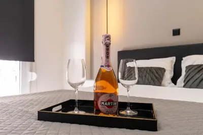 a bottle of champagne and two wine glasses on a table at Gkr Luxury Apartments Metro Petralona in Athens