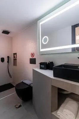a bathroom with a black toilet and a sink at Gkr Luxury Apartments Metro Petralona in Athens