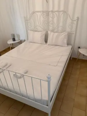a white bed with white sheets and pillows at Constantine cozy apartment in Piraeus