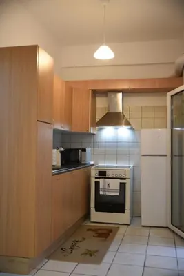 a kitchen with a stove and a white refrigerator at Constantine cozy apartment in Piraeus