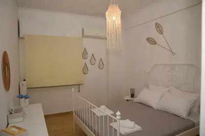 a small bedroom with a bed and a chandelier at Constantine cozy apartment in Piraeus