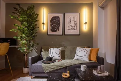 a living room with a couch and paintings on the wall at Asty60 - Cozy Athen's Apartment in Athens