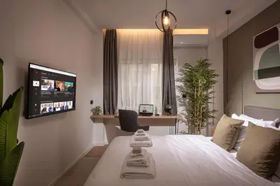 a bedroom with a bed and a tv on a wall at Asty60 - Cozy Athen's Apartment in Athens