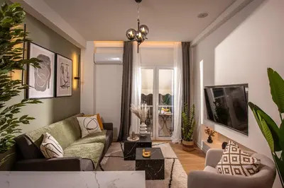a living room with a couch and a tv at Asty60 - Cozy Athen's Apartment in Athens