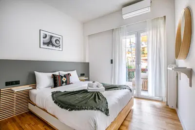 a bedroom with a bed and a large window at Belmont - 2 BR Apartment & Balcony in Athens in Athens