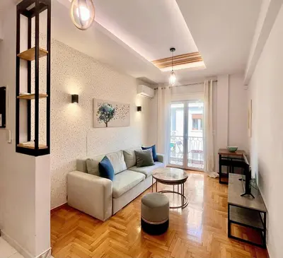 a living room with a couch and a table at Bright Athens Apt Near Metro, Balcony & Workspace in Athens