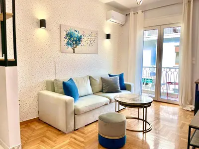 a living room with a couch and a table at Bright Athens Apt Near Metro, Balcony & Workspace in Athens