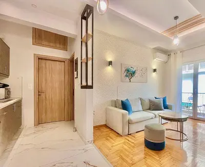 a living room with a couch and a table at Bright Athens Apt Near Metro, Balcony & Workspace in Athens