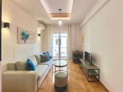 a living room with a couch and a tv at Bright Athens Apt Near Metro, Balcony & Workspace in Athens