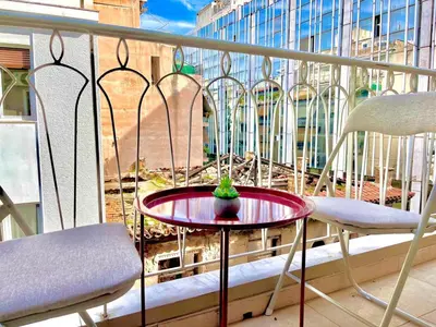 a small table on a balcony with two chairs at Bright Athens Apt Near Metro, Balcony & Workspace in Athens