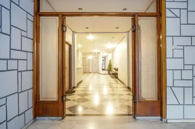 an open hallway with wooden doors and tiled walls at Cozy Nest, One-Bedroom Flat in Athens
